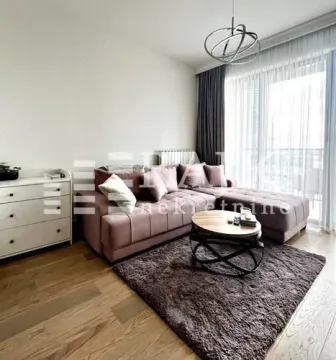 Living room with a sectional sofa, coffee table, and rug. - image 2