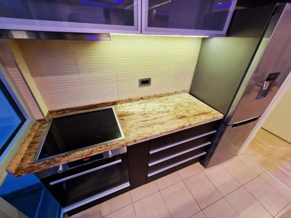 Modern kitchen with built-in oven, hob, and refrigerator.