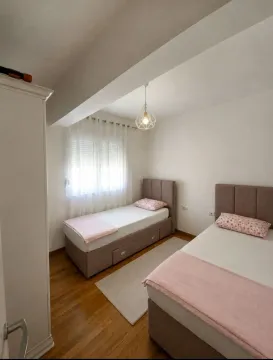 Bedroom with two single beds and a white wardrobe. - image 6