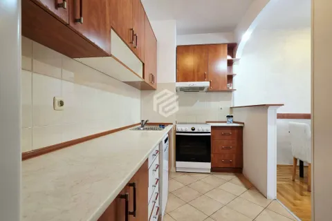 Smaller kitchen with wooden cabinets and built-in appliances. - image 10