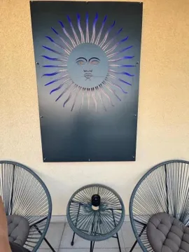 Manji balkon opremljen sa dvije stolice, stočićem i dekorativnim elementom na zidu. - image 9