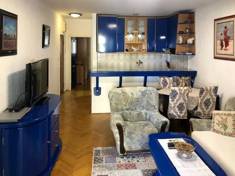 Living room with seating area, television, and dining space connected to the kitchen. - image 3
