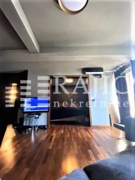 Living room with hardwood floors and TV. - image 3