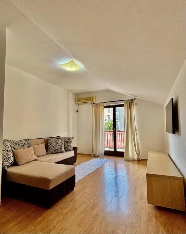 Living room with a sofa, TV, and access to the terrace.