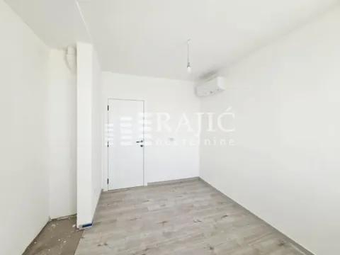 Empty room with white walls, laminate flooring, and an air conditioner. - image 8