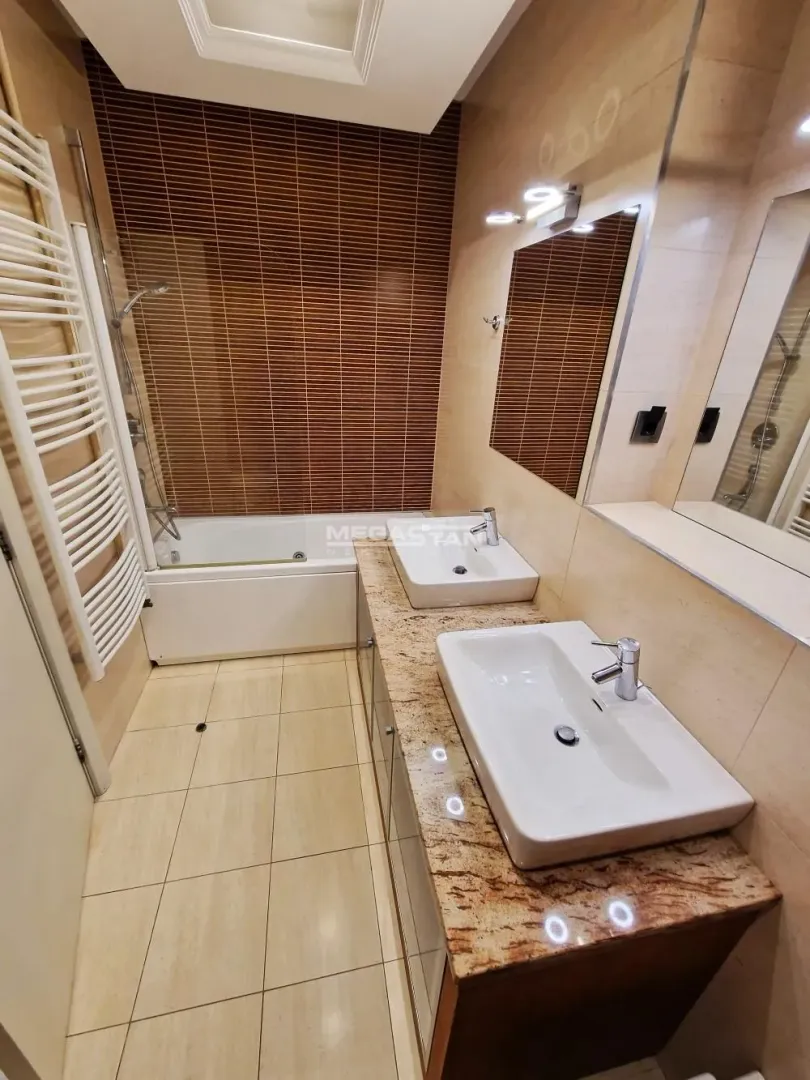 Modern bathroom equipped with two washbasins and a bathtub.