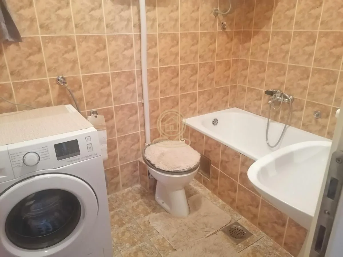 Kupatilo opremljeno kadom, umivaonikom, WC šoljom i veš mašinom.