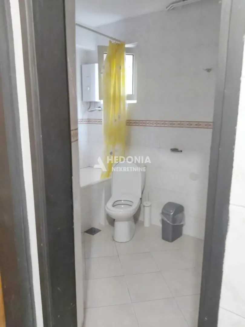 Pogled na kupatilo sa kadom, toaletom i prozorom.
