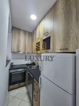 Smaller kitchen with wooden elements and a white refrigerator. - image 6