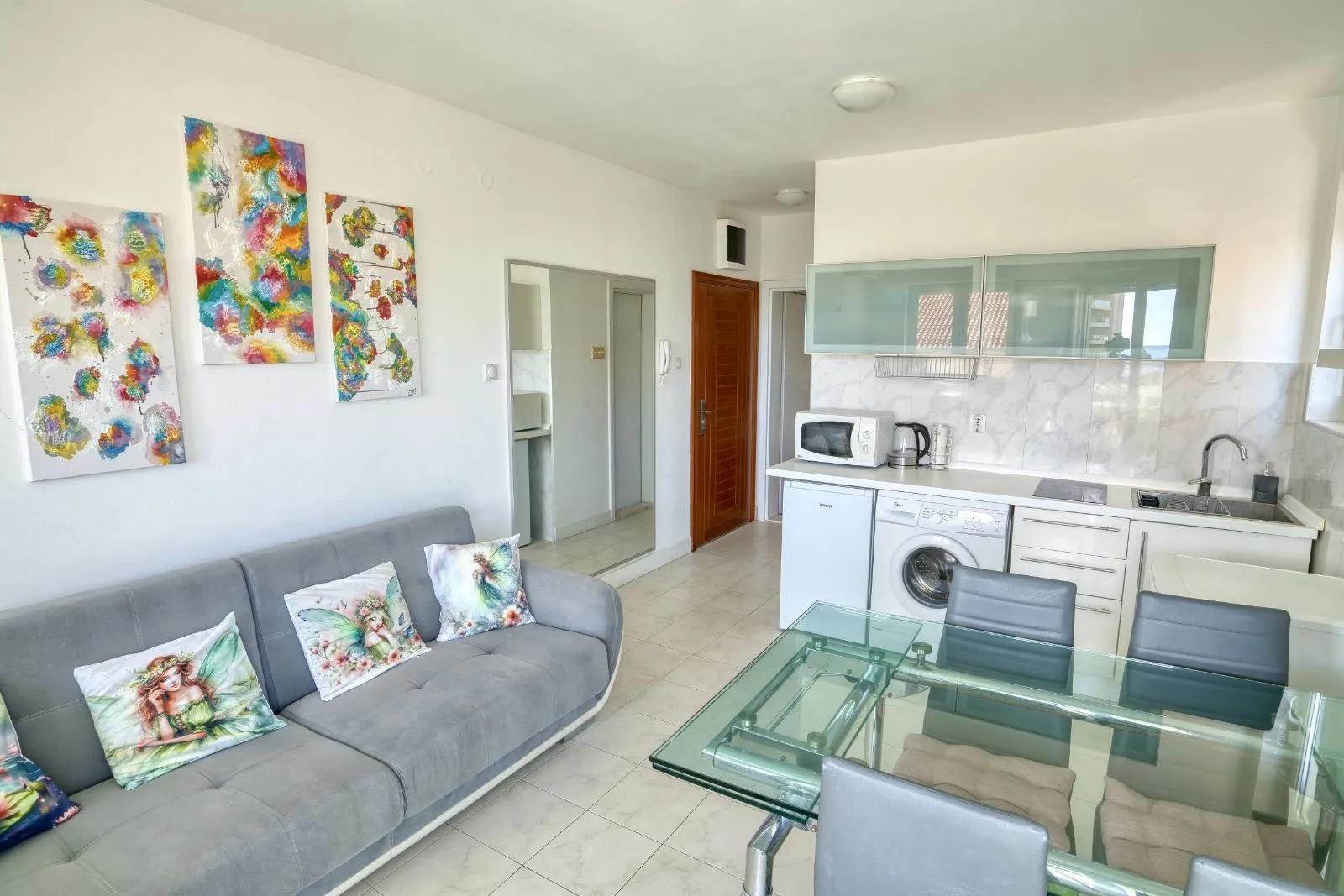 Living room with a sofa, dining table, and kitchen area.