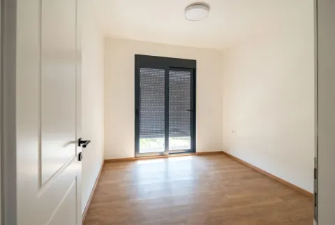 Prazna soba sa parketom i balkonskim vratima sa roletnama. - image 6