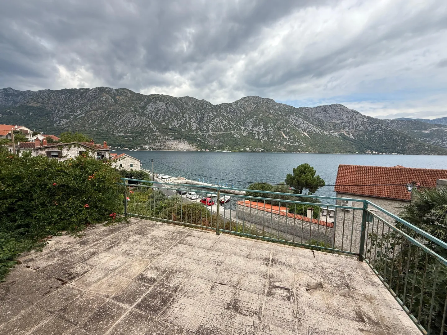 Pogled na more i planine sa popločane terase sa ogradom.