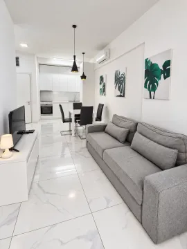 Living room with a sofa and dining area in an open-plan space. - image 7