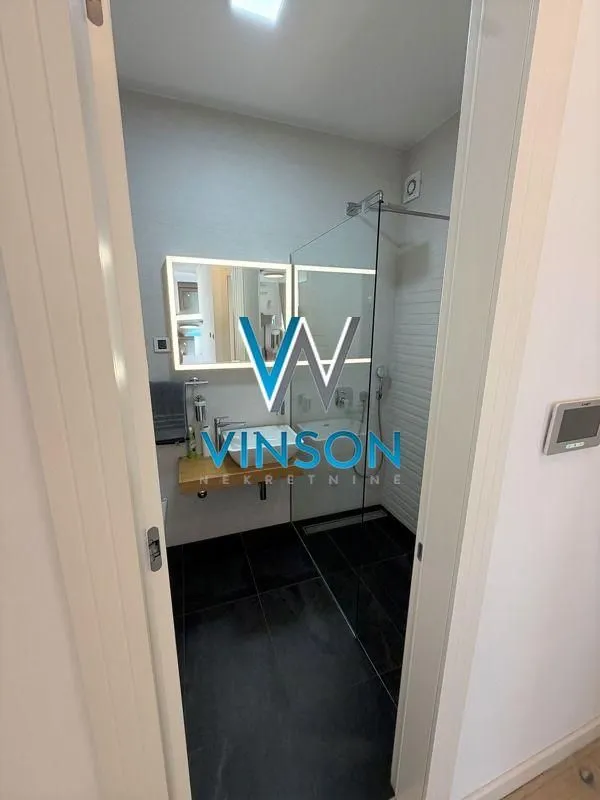 View through the doorway into a modern bathroom with a walk-in shower.