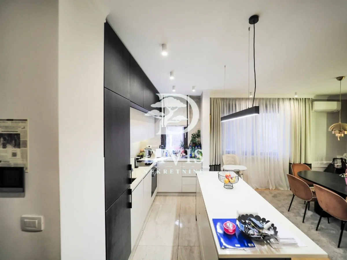 Modern kitchen with white and dark cabinetry and a dining area.