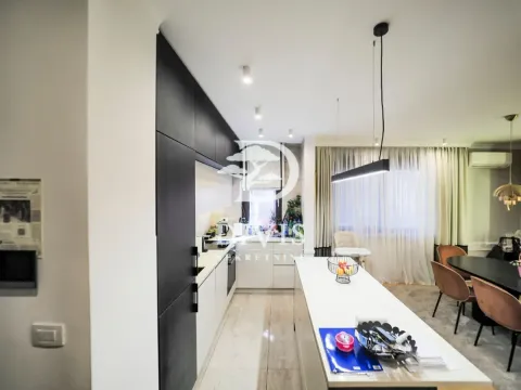 Modern kitchen with white and dark cabinetry and a dining area. - image 15