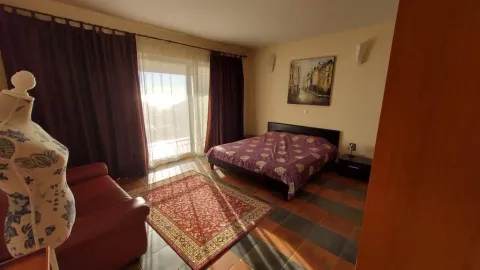 Prostrana spavaća soba sa bračnim krevetom, crvenim tepihom i izlazom na terasu. - image 6