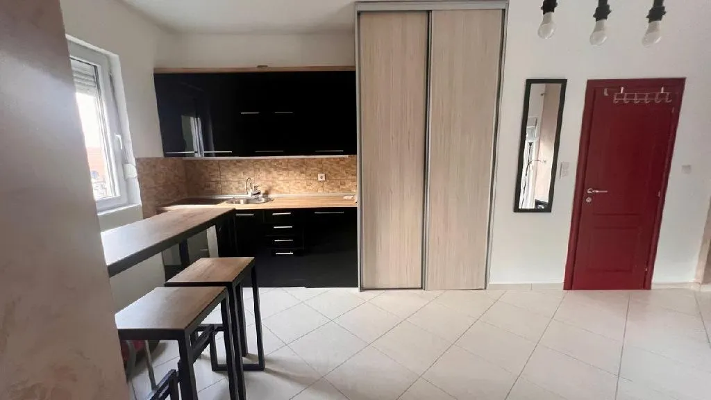 Small kitchen with black cabinets and a dining table integrated into the space.