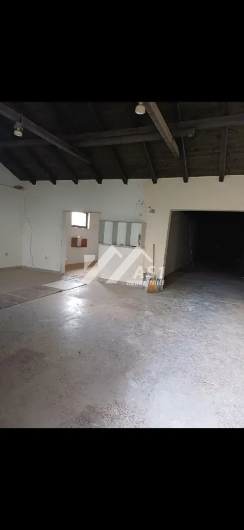 Unfinished interior space with a wooden roof structure.