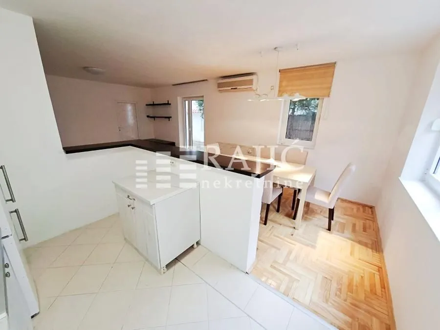 Interior view of the kitchen and dining area with parquet flooring.