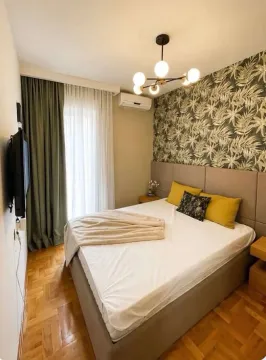 Furnished bedroom with a double bed, patterned wallpaper, and access to the terrace. - image 9