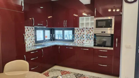 Kuhinja u obliku slova L sa sjajnim crvenim elementima i ugrađenom rernom. - image 3