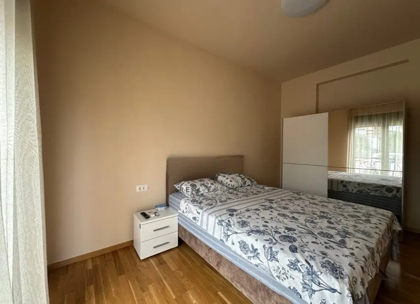 Furnished bedroom with a double bed, nightstand, and wardrobe.