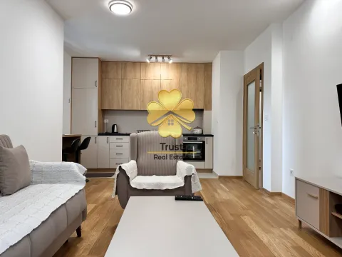 Living room with a sofa set and kitchen in the background. - image 3