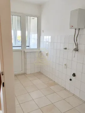 Prazna kuhinja sa pločicama na zidu i vratima koja vode na terasu. - image 14