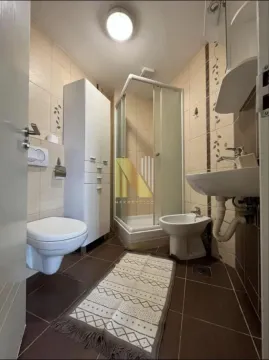 Kupatilo opremljeno tuš kabinom, sanitarijama i belim ormarićem. - image 9