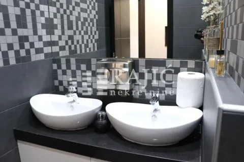 Modern bathroom with two washbasins and dark mosaic tiles. - image 9