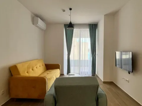 Dnevna soba sa žutim kaučom, foteljom i zidnim televizorom. - image 25