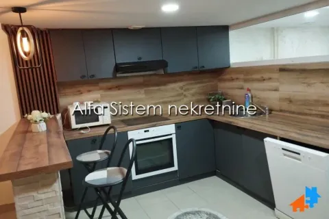 Modern kitchen with dark cabinets, wooden countertops, and a bar. - image 10