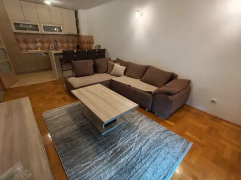 Living room with a sectional sofa and a view of the kitchen in the background. - image 5