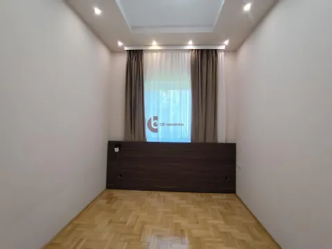 Empty bedroom with parquet flooring and a window with curtains. - image 29