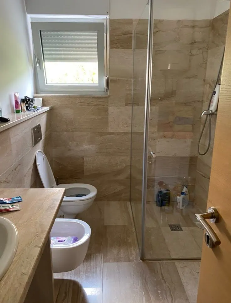Smaller tiled bathroom with a walk-in shower.