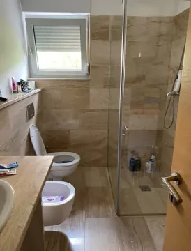 Smaller tiled bathroom with a walk-in shower. - image 5
