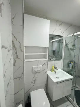 Modern bathroom with a sink, toilet, and shower cabin. - image 8
