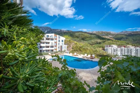 View of the outdoor swimming pool and surrounding buildings with greenery. - image 4