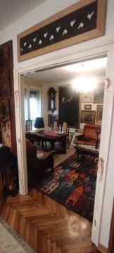 Pogled iz hodnika na dnevnu sobu sa umetničkim slikama i trpezarijskim stolom. - image 4