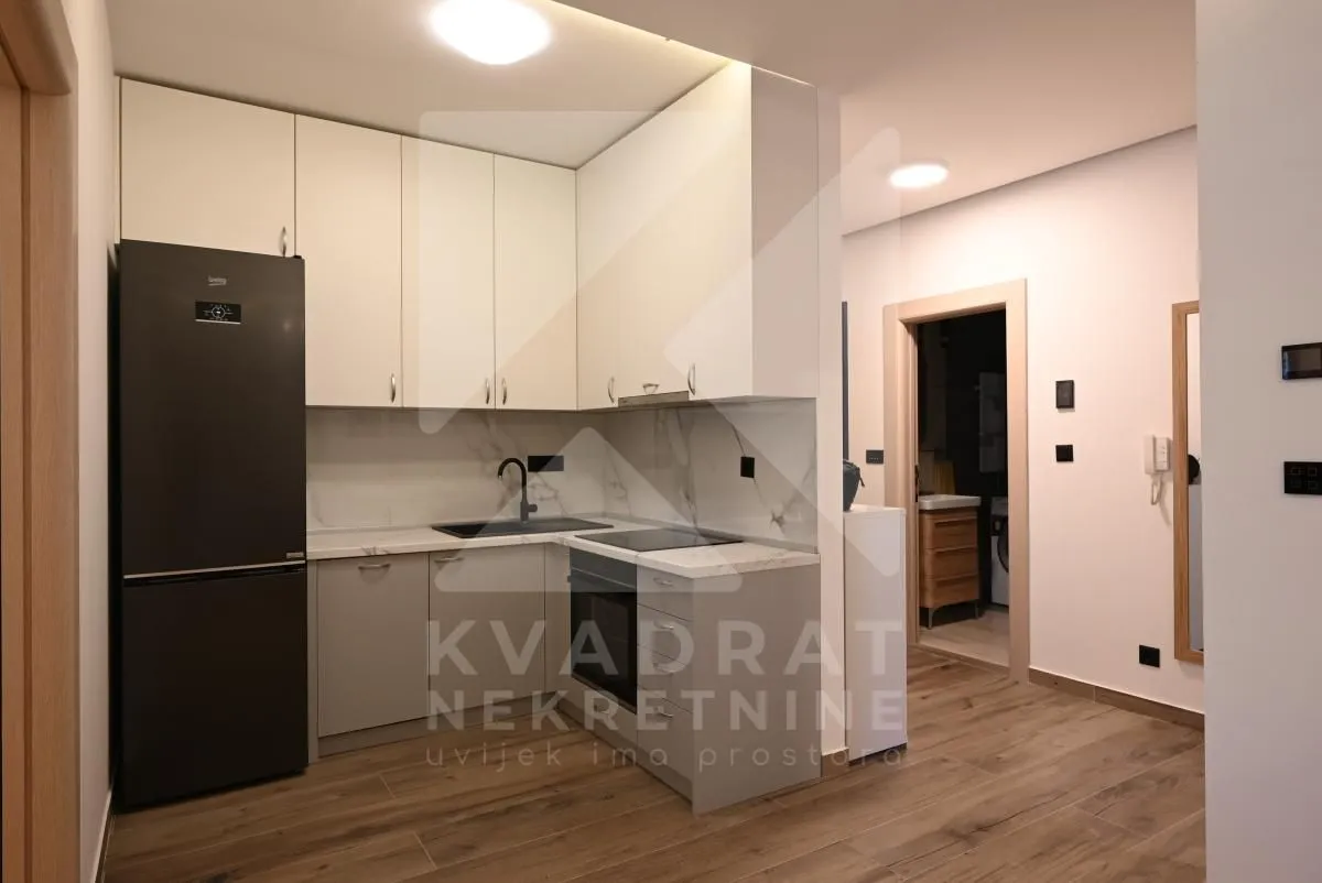 Modern kitchen with fitted units and a black refrigerator.