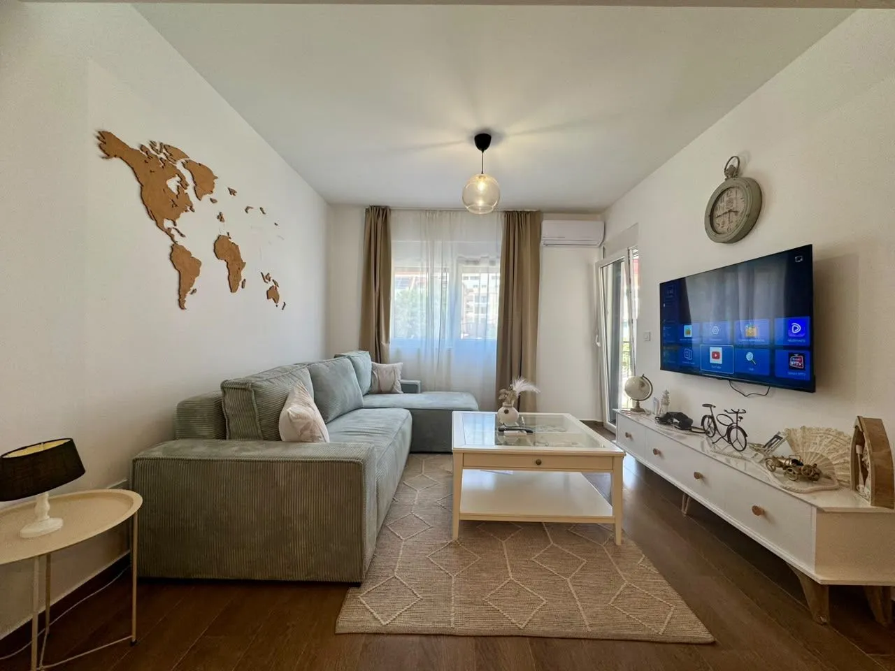Comfortable living room with a sofa, TV, and a decorative world map on the wall.