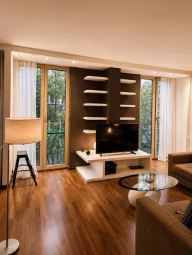 Living room with sofa, TV, and balcony access. - image 3
