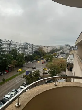 View from a balcony overlooking a city street and buildings on a cloudy day. - image 5