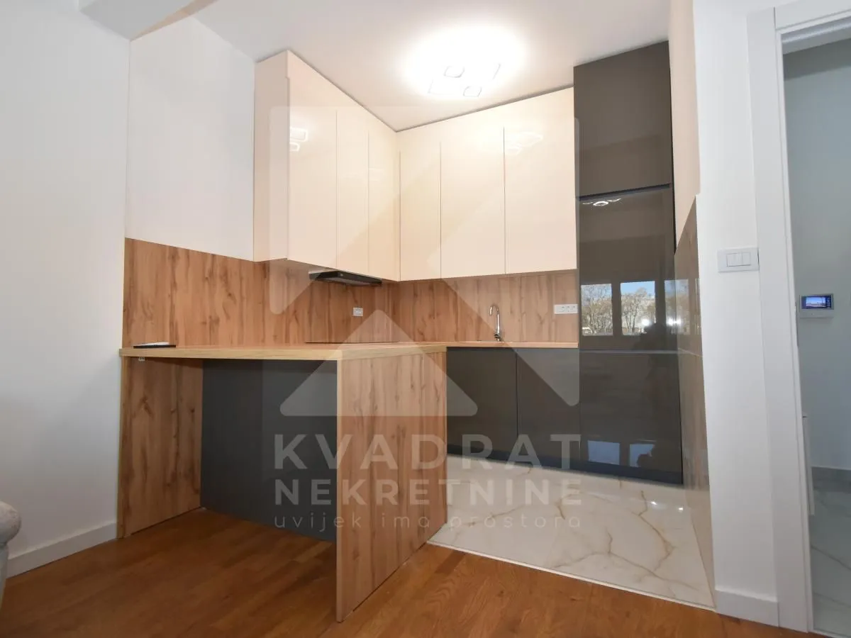 Modern kitchen with wooden elements and built-in cabinets.