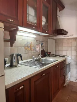 Kuhinja sa drvenim elementima, sudoperom i ugradnim šporetom. - image 6