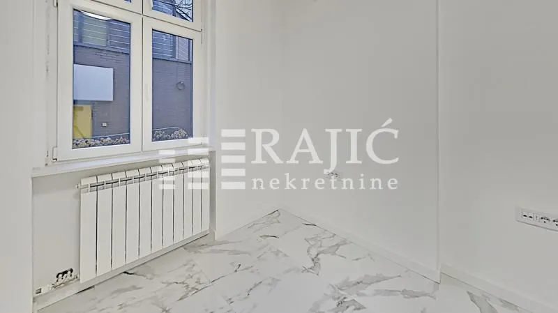 Empty room with white walls and marble tile flooring.
