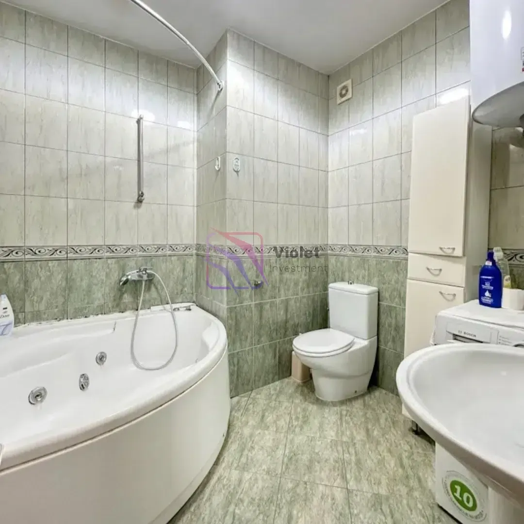 Kupatilo opremljeno ugaonom kadom, wc šoljom, umivaonikom i veš mašinom.
