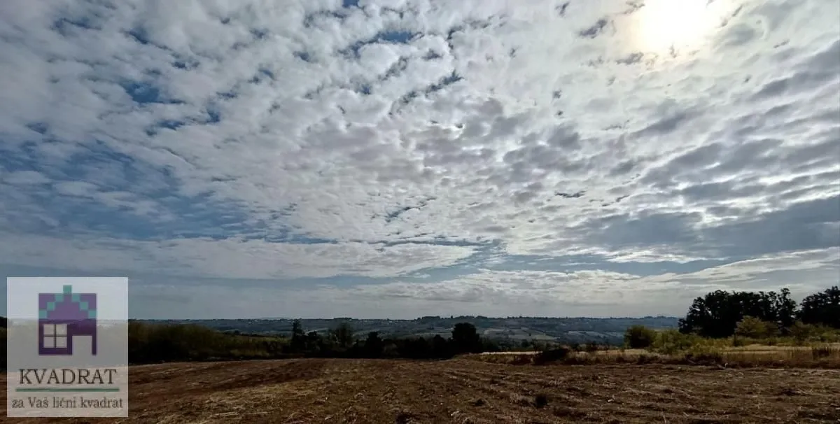 Pogled na otvoreni pejzaž i oblačno nebo iznad imanja.
