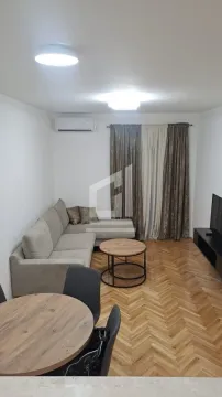 Living room with a corner sofa, coffee table, TV, and dining table. - image 2